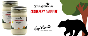 Graphic of Cranberry Campfire Collection scent - featuring Byrd Apothecary Cranberry Campfire Soy Candle. The background is an image of a black bear walking from behind a tree.